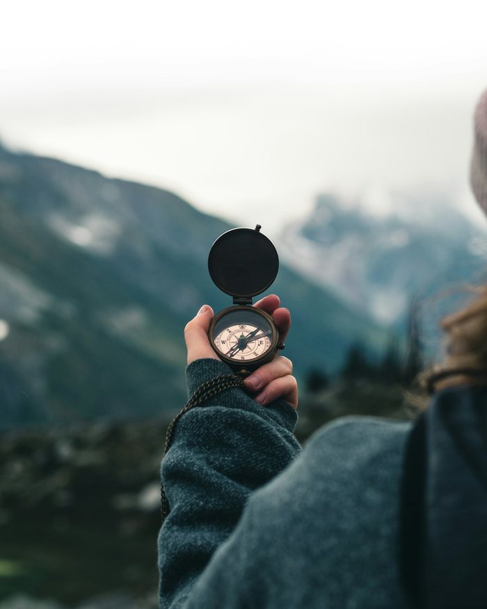 Kompass in der Hand vor Bergpanorama – Symbol für Orientierung und Veränderung